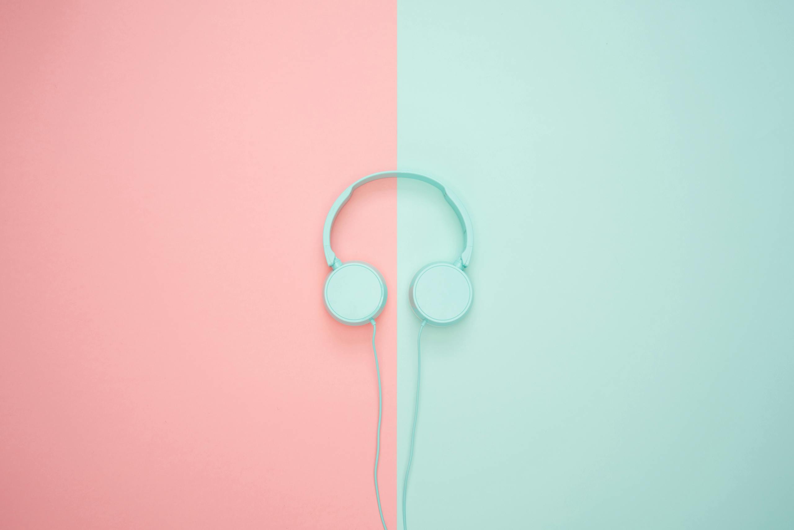 Minimalist headphones on a pink and mint background, artistic and modern.